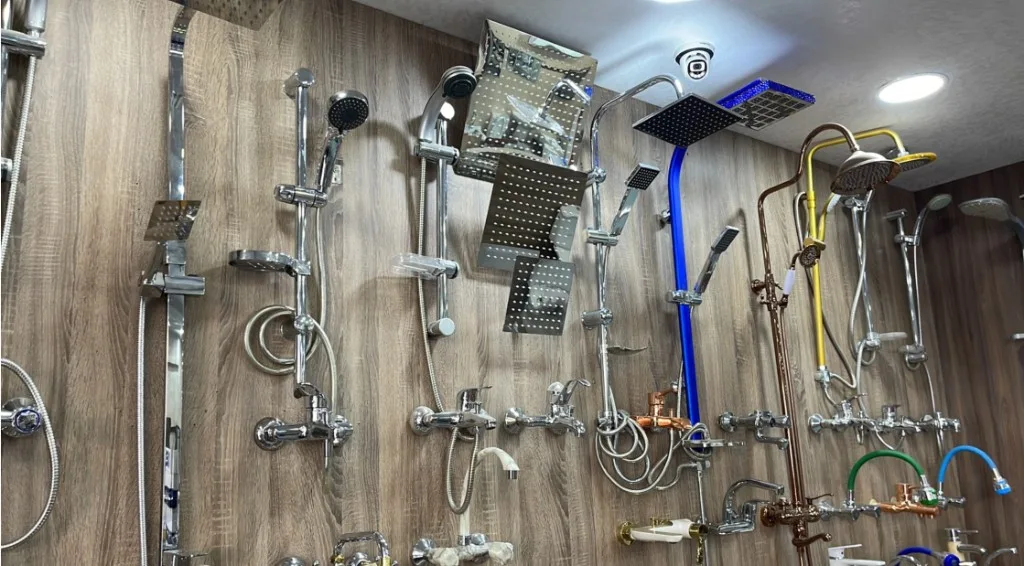 Wall-mounted shower columns, rainfall heads, and mixer taps in chrome, gold, and colour finishes